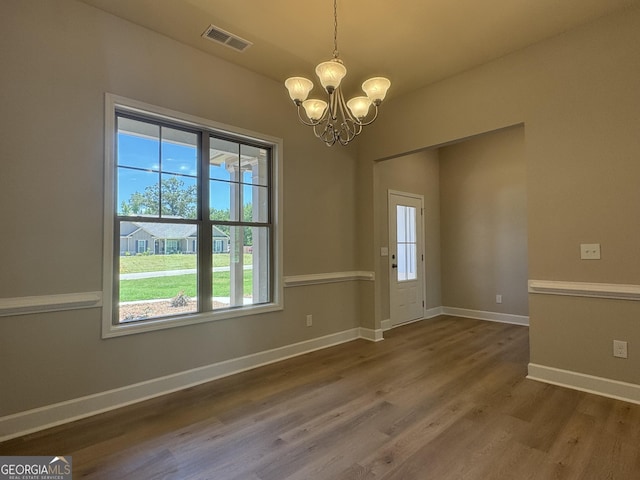 interior space featuring an inviting chandelier, dark wood-type flooring, baseboards, and visible vents