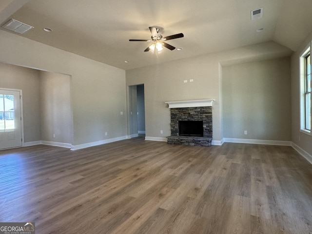 unfurnished living room featuring wood finished floors, a fireplace, visible vents, and baseboards