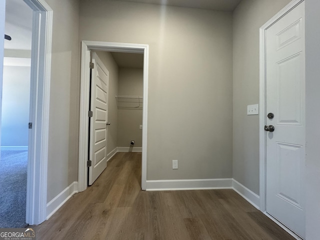 corridor with baseboards and dark wood-style floors