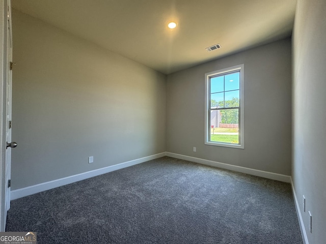 empty room featuring visible vents, carpet, and baseboards