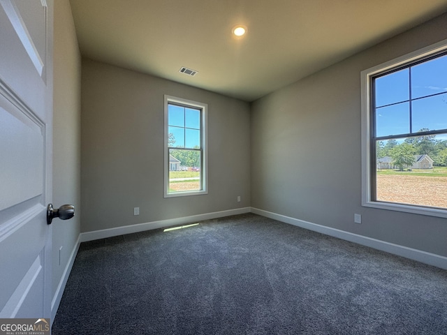 spare room featuring recessed lighting, visible vents, baseboards, and dark carpet