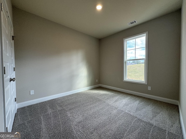 carpeted spare room featuring visible vents and baseboards