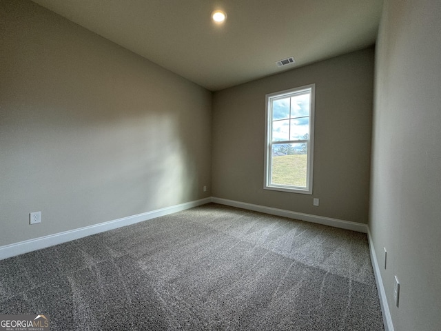 carpeted empty room featuring visible vents and baseboards