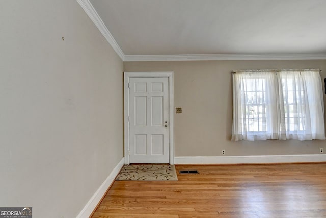 entrance foyer featuring crown molding, wood finished floors, baseboards, and visible vents