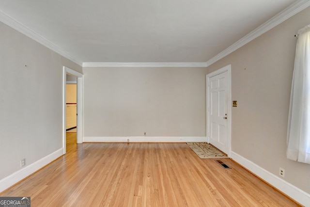 unfurnished room with baseboards, visible vents, light wood finished floors, and ornamental molding