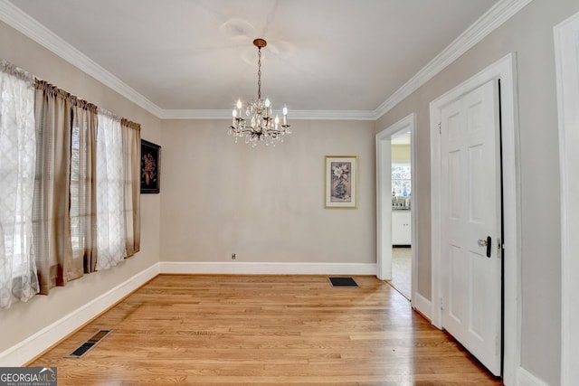 dining space with visible vents, light wood-style floors, and ornamental molding