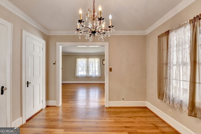 unfurnished dining area with baseboards, an inviting chandelier, light wood-style flooring, and crown molding