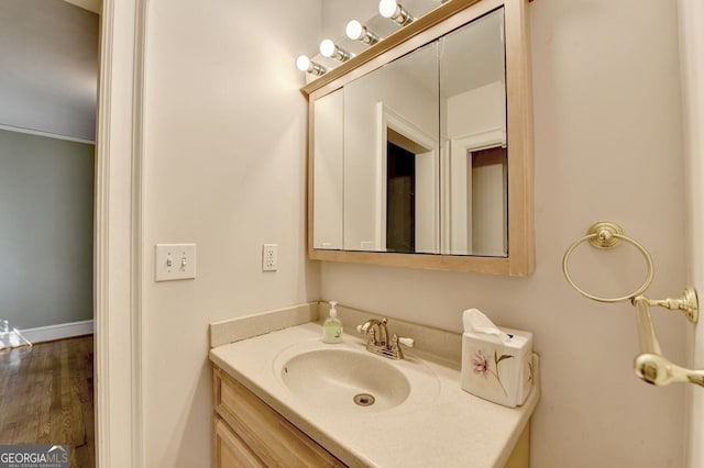 bathroom featuring vanity, baseboards, and wood finished floors