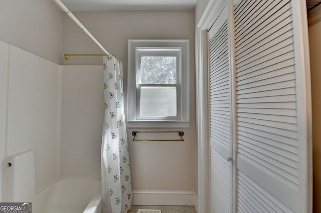 full bath with a closet and shower / tub combo with curtain