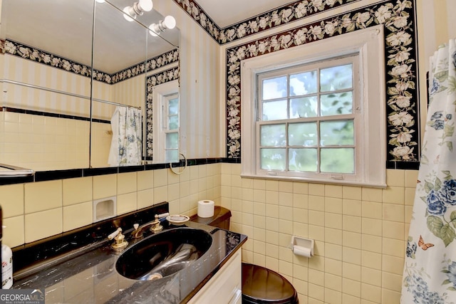 bathroom featuring a wainscoted wall, tile walls, vanity, and wallpapered walls