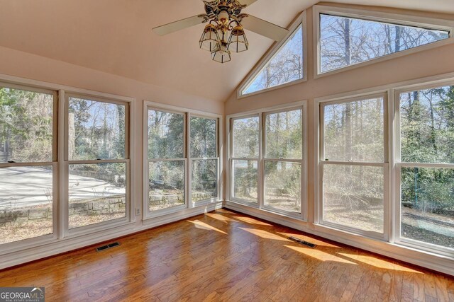 unfurnished sunroom with lofted ceiling, plenty of natural light, and visible vents