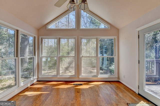 unfurnished sunroom featuring lofted ceiling, plenty of natural light, and visible vents