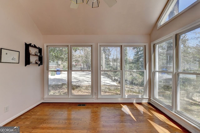 unfurnished sunroom featuring visible vents and lofted ceiling