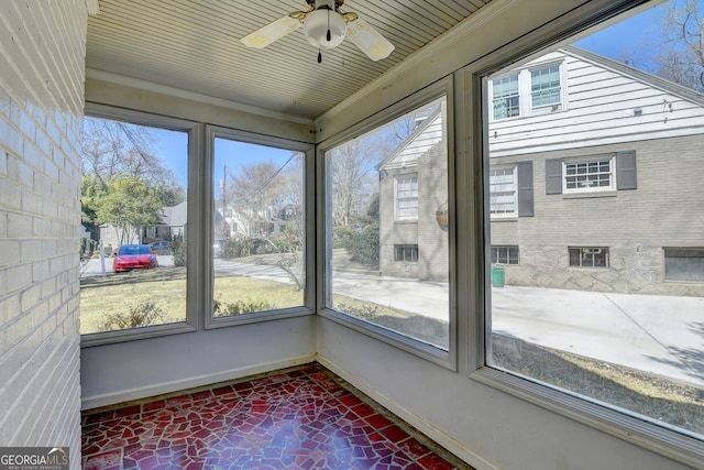 unfurnished sunroom featuring ceiling fan