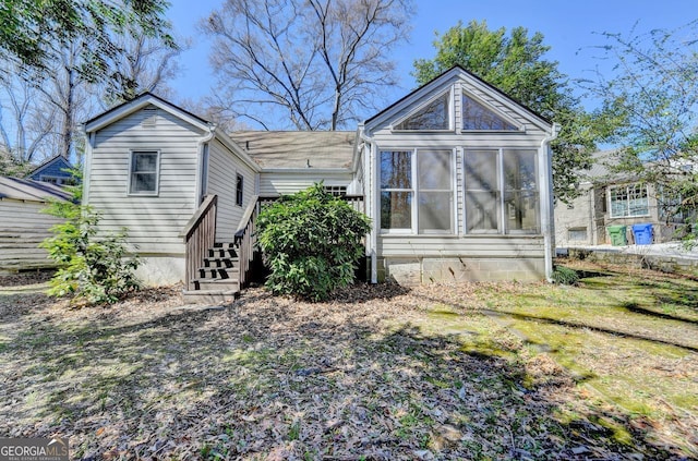 rear view of house featuring a sunroom