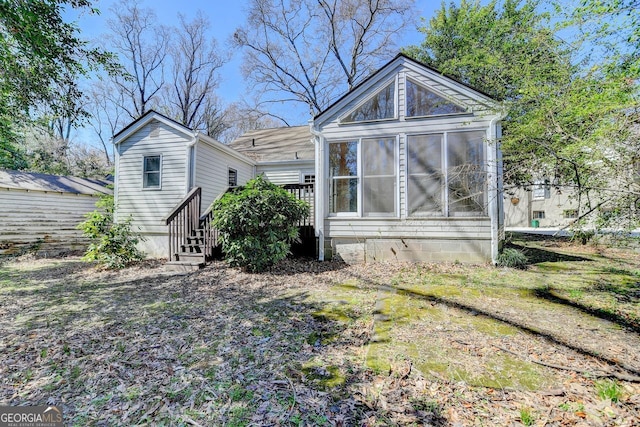 rear view of house featuring a sunroom