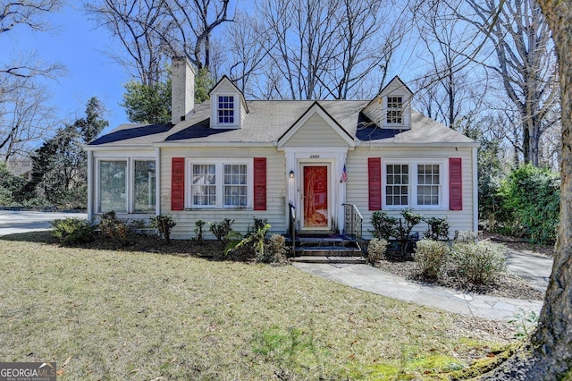 cape cod-style house with a chimney and a front lawn