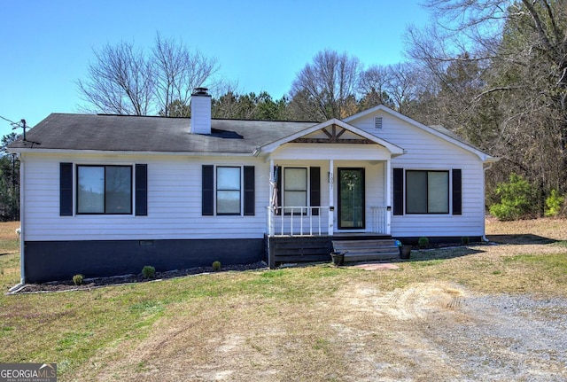 view of front of house featuring crawl space, a porch, a chimney, and a front lawn