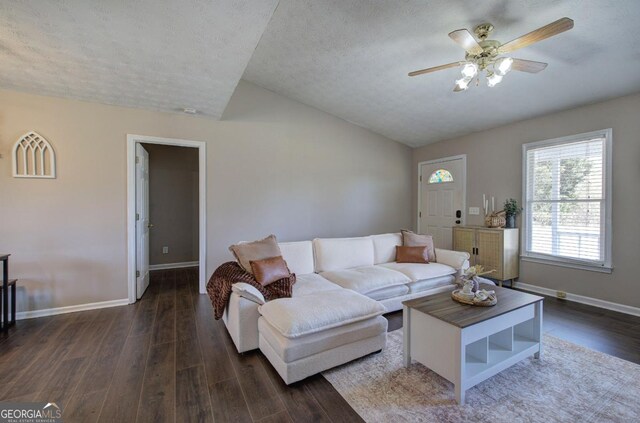 living area with baseboards, lofted ceiling, dark wood-style floors, a textured ceiling, and a ceiling fan