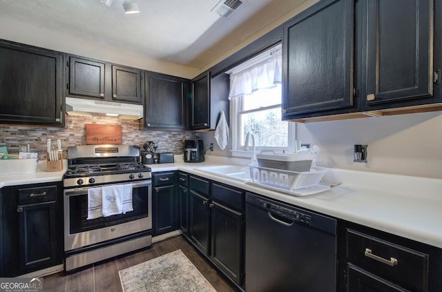 kitchen featuring visible vents, under cabinet range hood, dark wood-style floors, dishwasher, and stainless steel range with gas stovetop