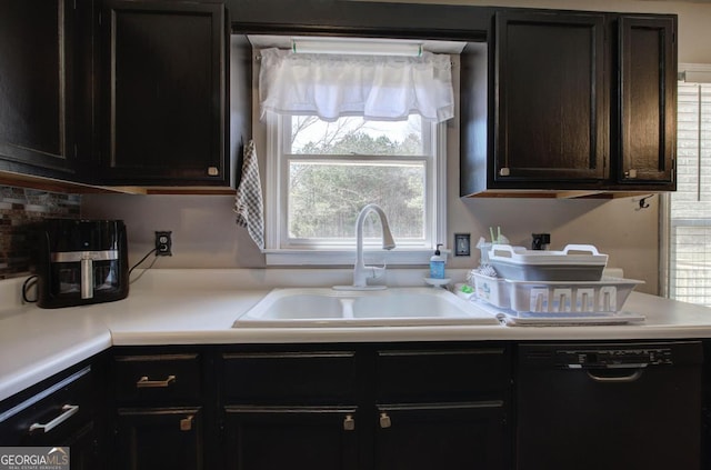 kitchen featuring light countertops, black dishwasher, and a sink