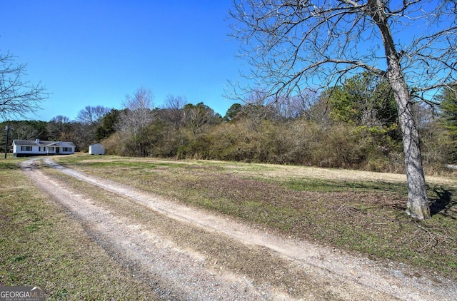 view of street with a forest view and driveway