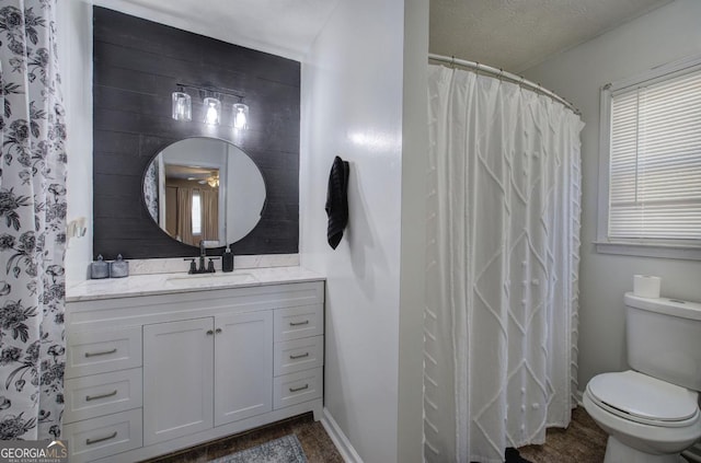 full bath featuring toilet, vanity, and baseboards