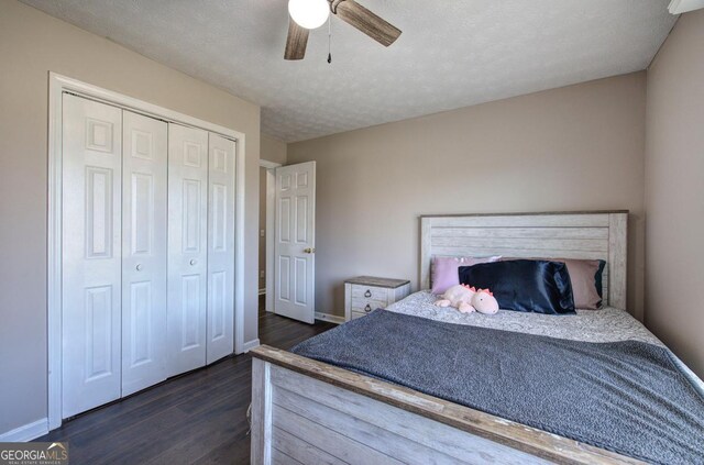 bedroom with a closet, ceiling fan, dark wood-type flooring, and baseboards