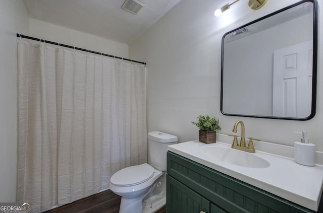 full bathroom featuring vanity, toilet, wood finished floors, and visible vents