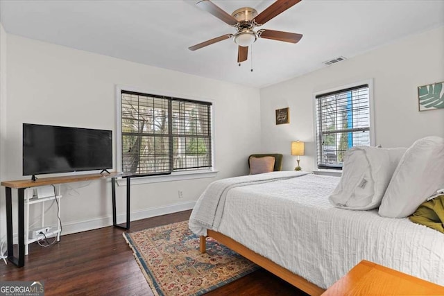 bedroom featuring visible vents, baseboards, wood finished floors, and a ceiling fan