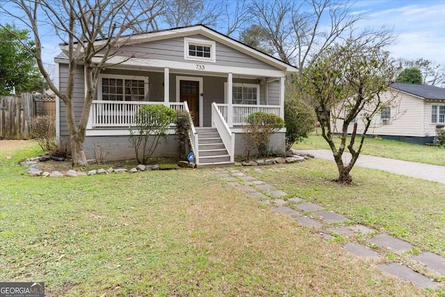 bungalow-style house with a front yard, stairway, a porch, and fence