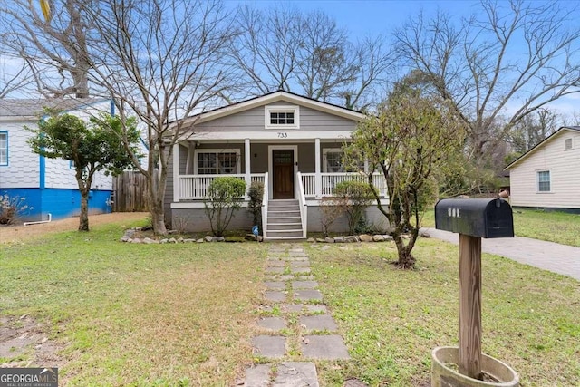 bungalow with a porch and a front lawn