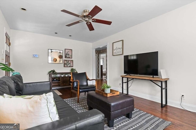 living area featuring baseboards, wood finished floors, and a ceiling fan