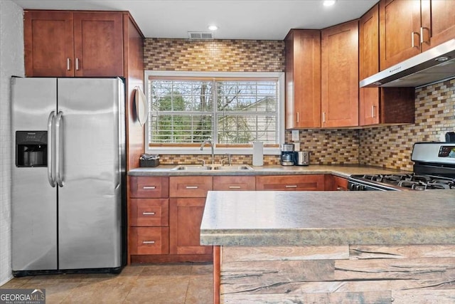 kitchen with visible vents, under cabinet range hood, decorative backsplash, appliances with stainless steel finishes, and a sink