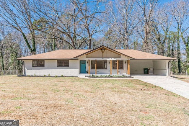 ranch-style house with an attached carport, a front yard, concrete driveway, and brick siding