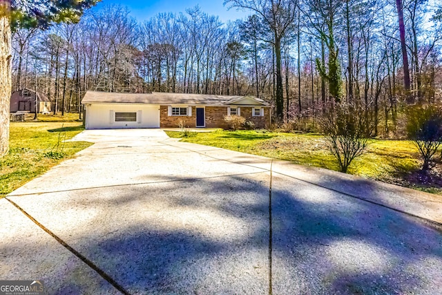 single story home with concrete driveway and a front lawn