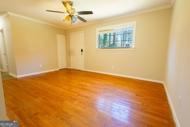 unfurnished room featuring ceiling fan, light wood-style flooring, baseboards, and ornamental molding