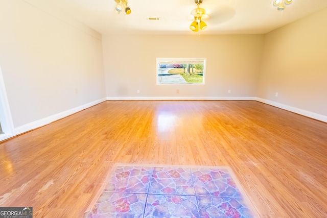 empty room with visible vents, baseboards, and wood finished floors