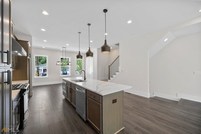 kitchen featuring a sink, stainless steel appliances, dark wood-type flooring, and an island with sink