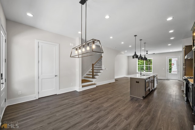 kitchen featuring a center island with sink, dark wood-style floors, open floor plan, recessed lighting, and baseboards