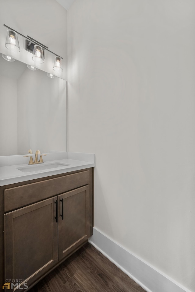 bathroom with baseboards, wood finished floors, and vanity