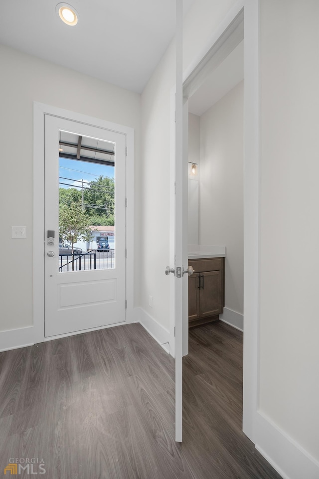 doorway with recessed lighting, baseboards, and dark wood-type flooring