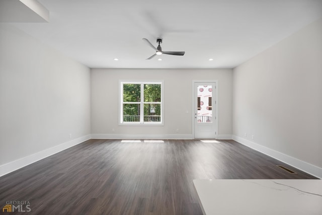 unfurnished living room with a ceiling fan, recessed lighting, dark wood-style floors, and baseboards