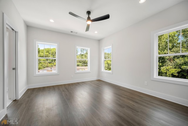 empty room with dark wood finished floors, visible vents, recessed lighting, and baseboards