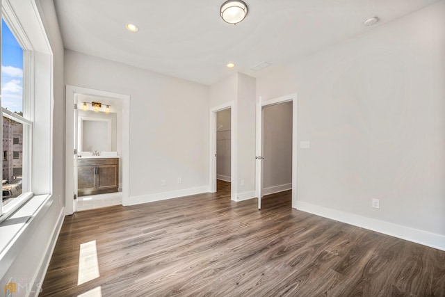 unfurnished room with a sink, recessed lighting, baseboards, and wood finished floors