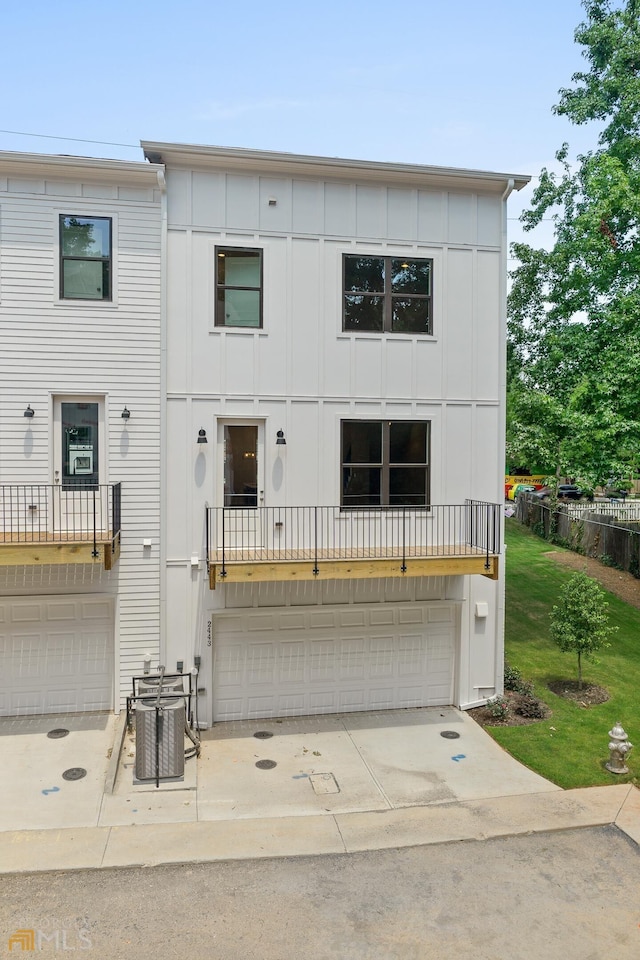 view of front of house featuring a garage, board and batten siding, central AC, and driveway