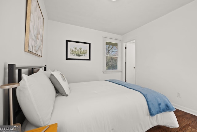 bedroom featuring wood finished floors and baseboards