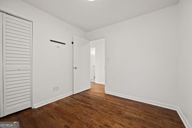 unfurnished bedroom featuring wood finished floors and baseboards