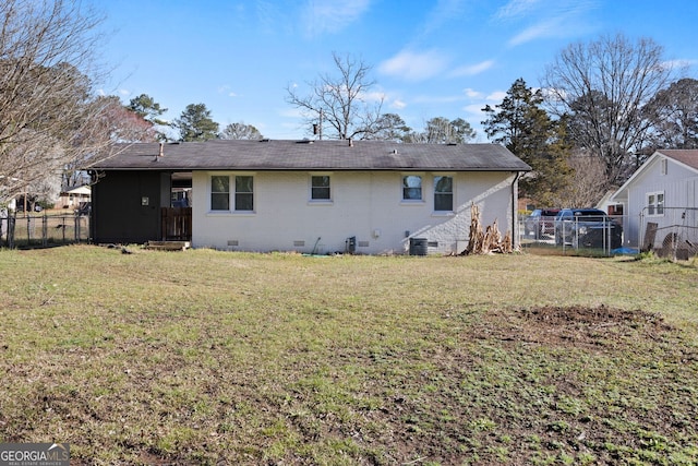 rear view of house featuring crawl space, a lawn, brick siding, and fence