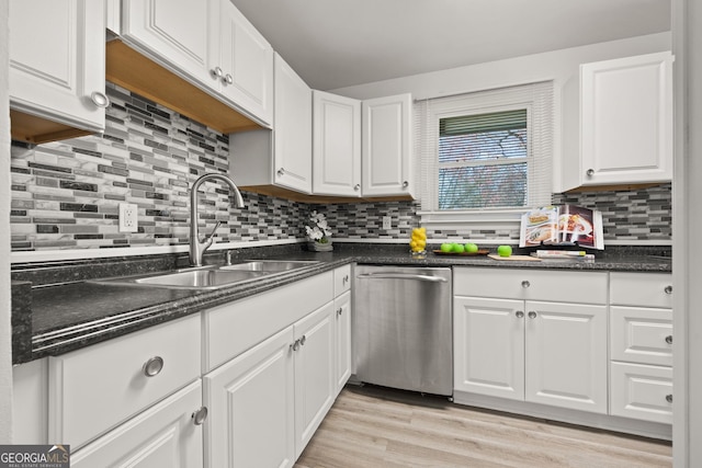kitchen with a sink, light wood-style flooring, stainless steel dishwasher, and white cabinets